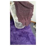 Purple Accent Rug, throw and White Wicker Chair.