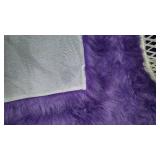 Purple Accent Rug, throw and White Wicker Chair.