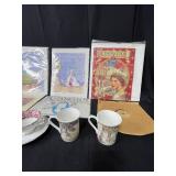 Lot of Great Britain/Royal Family Themed Collectibles, Coronation Coloring Book, Tea Cup and Saucer Set, 2 Park Scene Heirloom China Mugs and Small Wooden Display Case w/ Glass Door