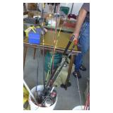 Bucket full of spinning reel fishing rods and fishing net