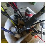 Bucket full of spinning reel fishing rods and fishing net