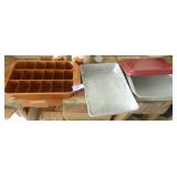 Three cake pans, two with covers and one with a cake cutter and a lift out sheet as well