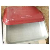 Three cake pans, two with covers and one with a cake cutter and a lift out sheet as well
