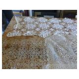 This lot has 4 large dresser scarves, some doilies and arm covers