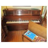 Everett piano with bench and sheet music