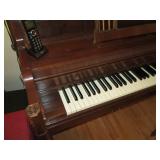 Everett piano with bench and sheet music
