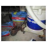 Corner contents behind the door of utility room including mens shoes and shop vac