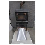 BLACK CAST IRON STOVE ON STAND WITH ROOF VENT