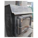 BLACK CAST IRON STOVE ON STAND WITH ROOF VENT