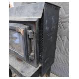 BLACK CAST IRON STOVE ON STAND WITH ROOF VENT