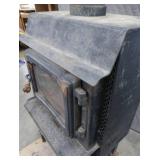 BLACK CAST IRON STOVE ON STAND WITH ROOF VENT
