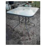 2 bar height glass top patio tables and 2 chairs