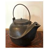 Two Teapots with Teacups including a Cast Iron Tea Kettle