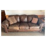 Used Brown Leather Sofa with Nailhead Trim and Throw Pillows