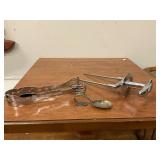 Lot of silverplate spoon, unmarked serving tong and carving piece.