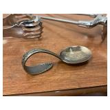 Lot of silverplate spoon, unmarked serving tong and carving piece.