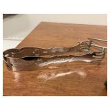 Lot of silverplate spoon, unmarked serving tong and carving piece.