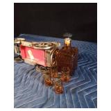Vintage metal car with decanter and 4 shot glasses in it