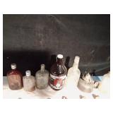 Vintage bottles and a growler and a lantern base