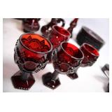 Collection of Ruby Red Glassware Including Goblets, Candlesticks, and Decorative Pieces