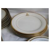Set of Elegant Porcelain Dinnerware with Gold Trim and Decorative Plate