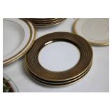Set of Elegant Porcelain Dinnerware with Gold Trim and Decorative Plate