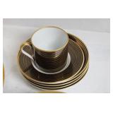 Set of Elegant Porcelain Dinnerware with Gold Trim and Decorative Plate