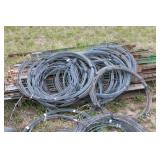 Collection of Electric Fence Supplies Including Wire, Insulators, and Energizer