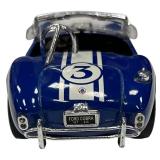 1:24 scale diecast model of a blue and white 1965 Shelby Cobra 427 S/C