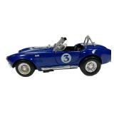 1:24 scale diecast model of a blue and white 1965 Shelby Cobra 427 S/C