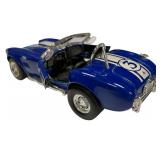 1:24 scale diecast model of a blue and white 1965 Shelby Cobra 427 S/C