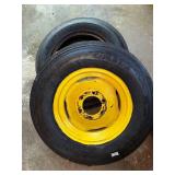 One Yellow Rimmed John Deere Front Tractor Tire and Second John Deere Tire