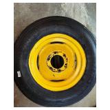 One Yellow Rimmed John Deere Front Tractor Tire and Second John Deere Tire