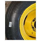 One Yellow Rimmed John Deere Front Tractor Tire and Second John Deere Tire
