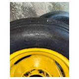 One Yellow Rimmed John Deere Front Tractor Tire and Second John Deere Tire