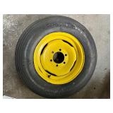 One Yellow Rimmed John Deere Front Tractor Tire and Second John Deere Tire