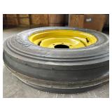 One Yellow Rimmed John Deere Front Tractor Tire and Second John Deere Tire