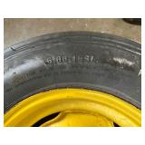 One Yellow Rimmed John Deere Front Tractor Tire and Second John Deere Tire