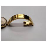 Oleg Cassini 32-420 quartz watch. Quartz watch with plain band and rhinestones on the dial face.