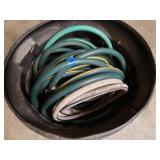 Garbage can full of garden hose