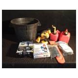 Tub of auto accessories, new tiedowns, chainsaw chain guard, Dewalt battery operated tools, and 2 gas cans