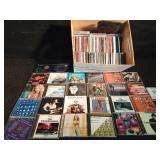 Lot of CDs and a visor cd holder and 1 cassette