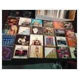 Lot of CDs and a visor cd holder and 1 cassette