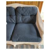 Wicker Loveseat with Navy Cushions and Plaid Pillow