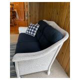 Wicker Loveseat with Navy Cushions and Plaid Pillow