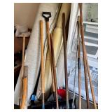Collection of Garden Tools Including Shovels, Axe, Hoes, Brooms, and Pitchfork