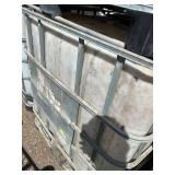 Stack of Used 275-Gallon IBC Tote Tanks with Metal Cages