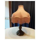 Vintage Table Lamp with an ornate base with intricate detailing and a fringed lampshade
