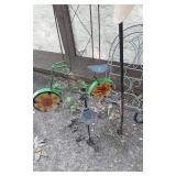 Metal garden decor including Shepherds hooks,  plant stands, bird decorations, and windmill