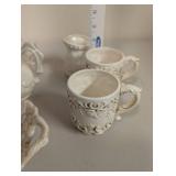 Collection of Embossed White Ceramic Serving Pieces and Mugs